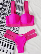 Biquíni rosa pink com top estruturado e alças largas, calcinha cavada rosa com tiras laterais duplas da mesma cor.