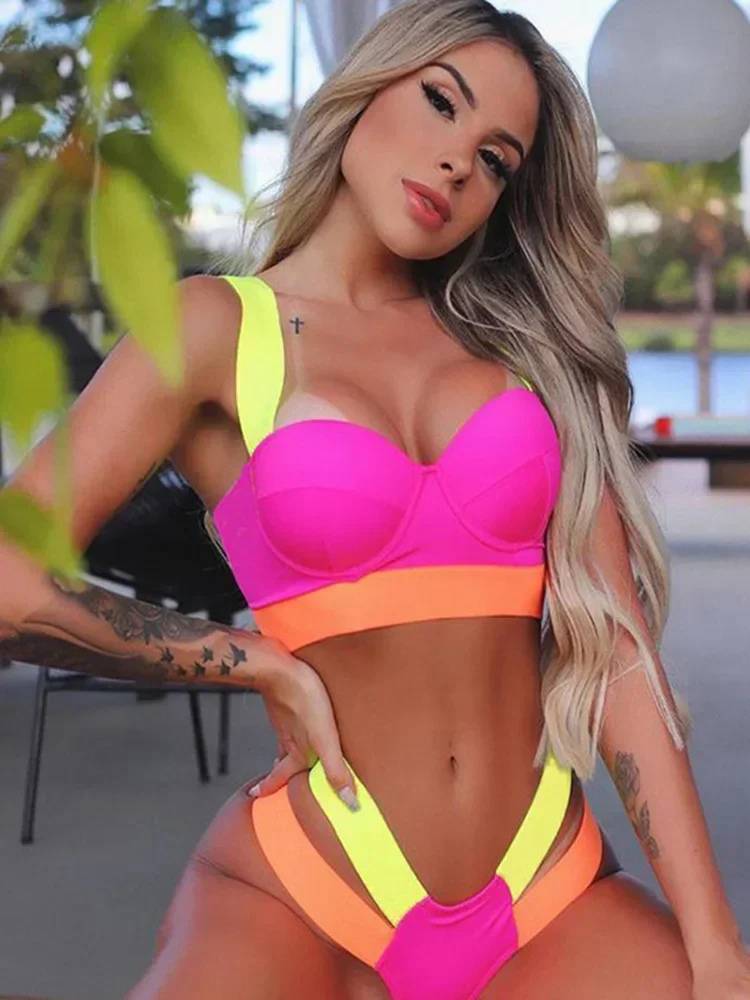 Modelo vestindo biquíni rosa pink com laranja e verde neon, top estruturado e calcinha cavada com tiras laterais largas.
