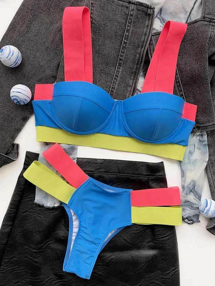 Biquíni colorido com top azul estruturado, alças largas rosa pink e faixa verde neon, acompanhado de calcinha azul com tiras duplas rosa e verde neon.