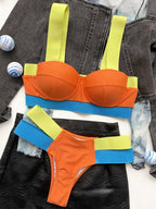Biquíni laranja vibrante com top estruturado, alças largas verde neon e faixa azul, com calcinha laranja e tiras laterais verde neon e azul.