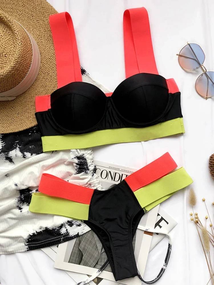 Biquíni preto com detalhes neon, top estruturado com alças rosa e faixa verde neon, calcinha preta com tiras duplas verde neon e rosa.