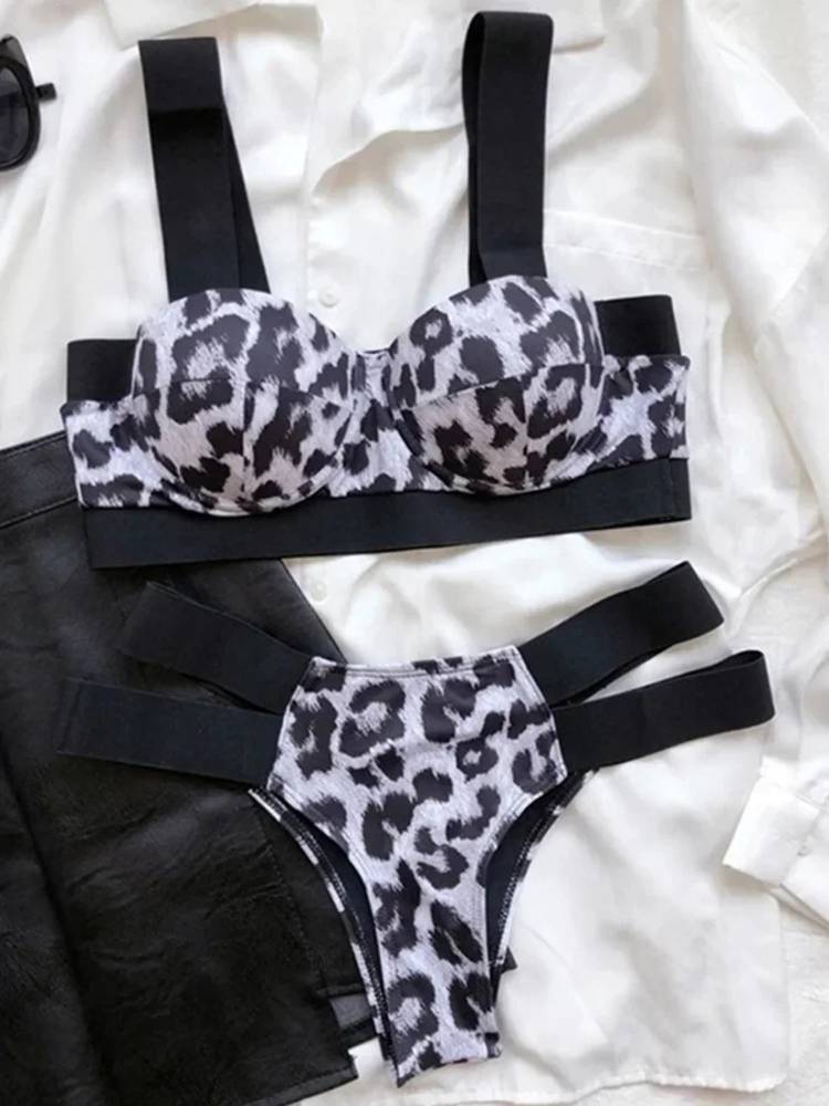 Biquíni estampa animal print preto e branco, top estruturado com alças largas pretas e calcinha com tiras laterais pretas.
