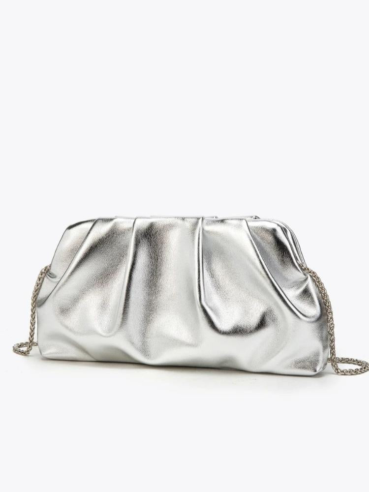 Bolsa clutch prata metalizada com pregas e alça de corrente prateada em fundo branco.