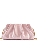 Bolsa clutch rosa metalizada com pregas e corrente dourada em fundo branco.