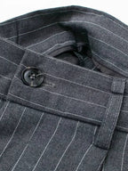 Detalhe do cós e botão da calça de alfaiataria cinza com risca de giz
