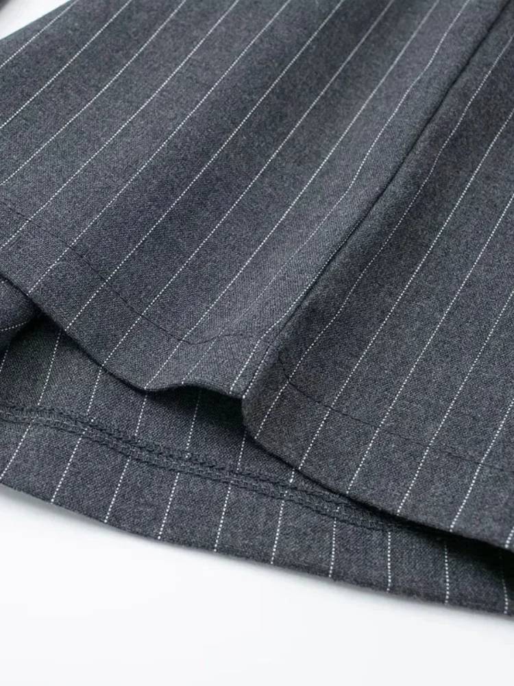 Detalhe da barra da calça larga cinza com risca de giz
