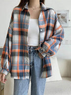 Camisa xadrez feminina em azul, laranja e branco, modelagem ampla, usada com top branco e jeans de cintura alta, estilo casual confortável.