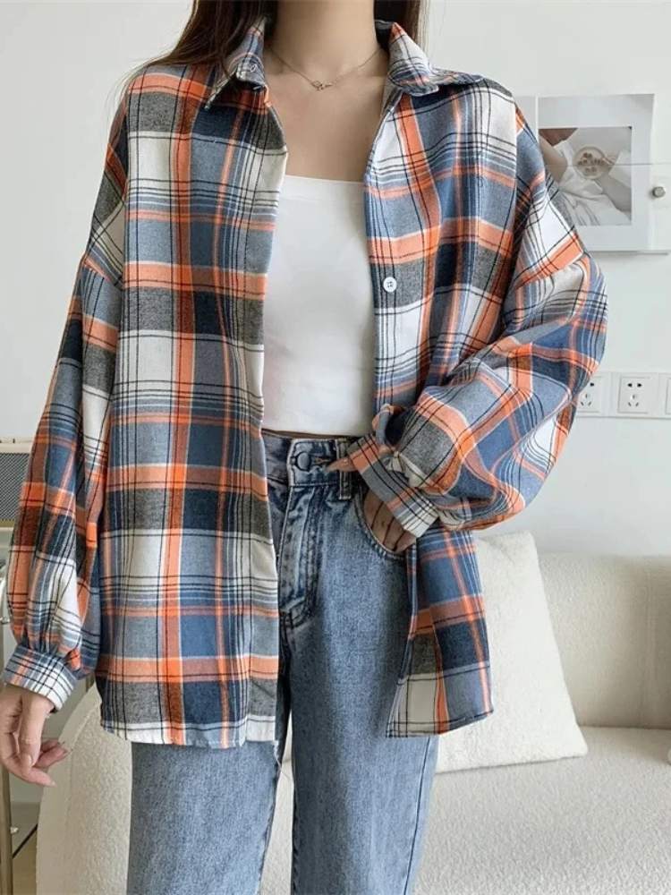 Camisa xadrez feminina em azul, laranja e branco, modelagem ampla, usada com top branco e jeans de cintura alta, estilo casual confortável.