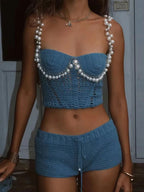 Conjunto azul de crochê completo com top de pérolas e shorts, modelo em pé
