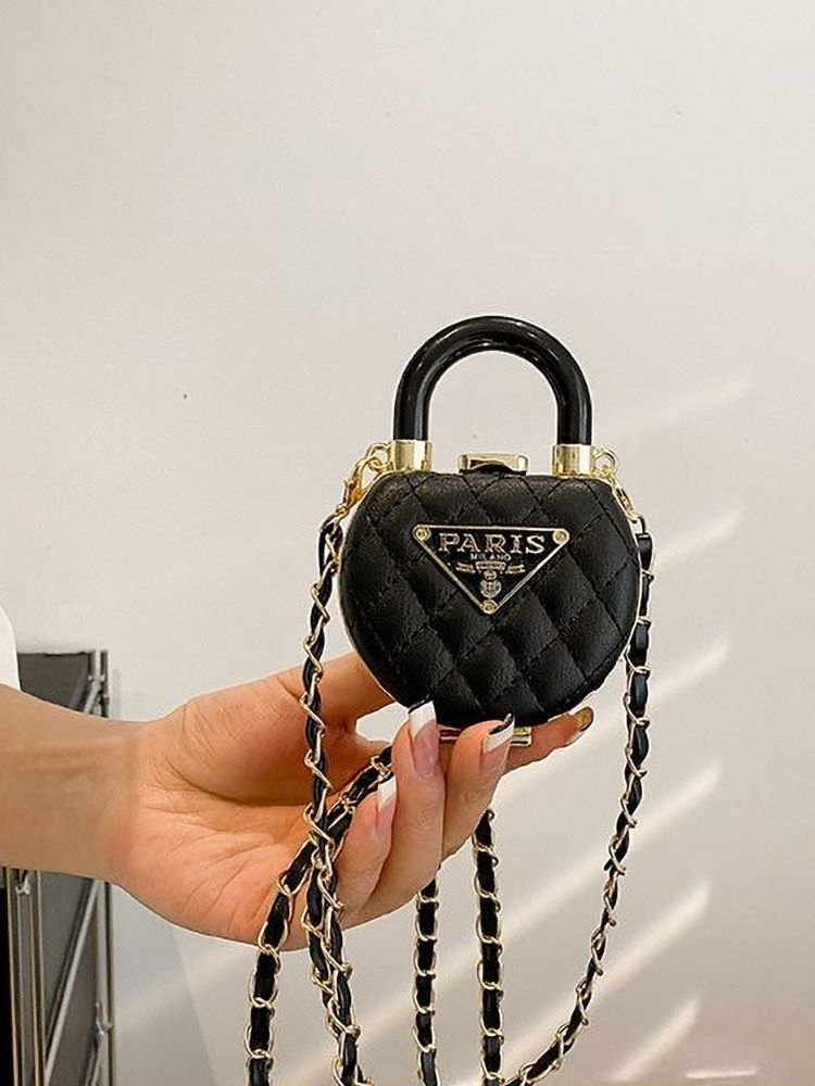 Mini bolsa preta acolchoada em formato de cadeado sendo segurada pela alça superior, exibindo corrente dourada