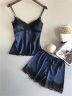 Conjunto de pijama feminino em cetim azul marinho com top de alças e renda preta no busto, ao lado de short azul marinho com renda preta na barra.