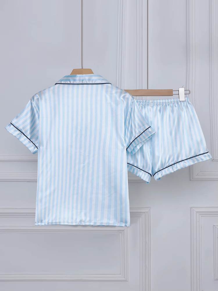 Conjunto de pijama feminino em cetim azul claro com listras verticais e acabamento preto, visto de costas, composto por camisa de manga curta e shorts.