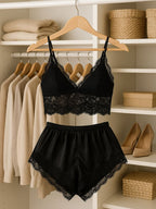 Conjunto de pijama feminino todo preto com top de renda e shorts de cetim com renda na barra pendurados em cabide dentro de um closet.