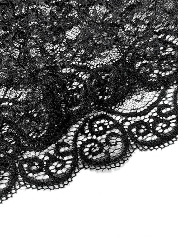 Close detalhado do tecido de renda preta com desenho floral e bordas onduladas.