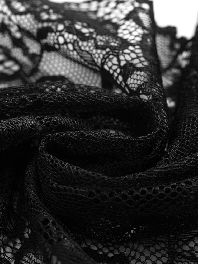 Detalhe do tecido de renda preta em close, mostrando textura rendada e transparência.