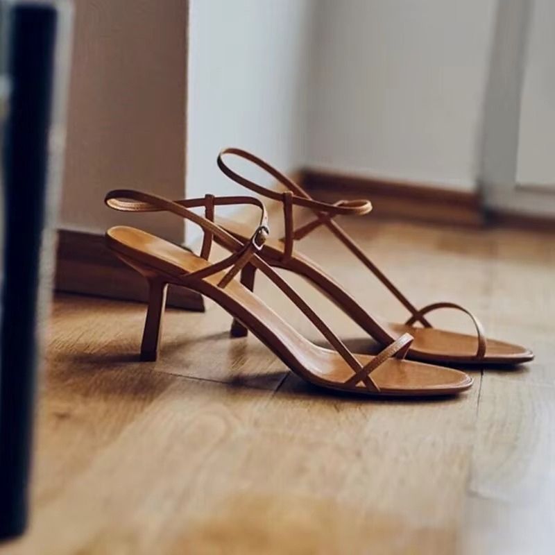 Sandália feminina caramelo com tiras finas cruzadas e salto fino, estilo elegante para looks sofisticados.