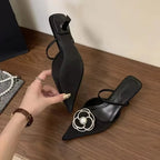 Sandálias femininas pretas de bico fino com solado antiderrapante e aplique de flor com pérola, mostradas em vista inferior e superior